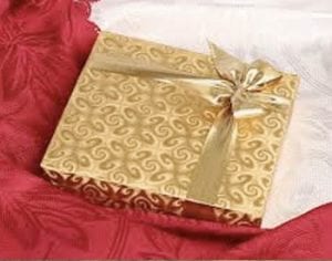 gold wrapped box of chocolates on bed
