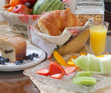 fruit muffin croissant orange juice breakfast on table